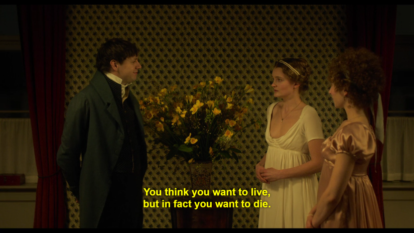 a man faces two women in period costume and speaks the words "You think you want to live, but in fact you want to die"