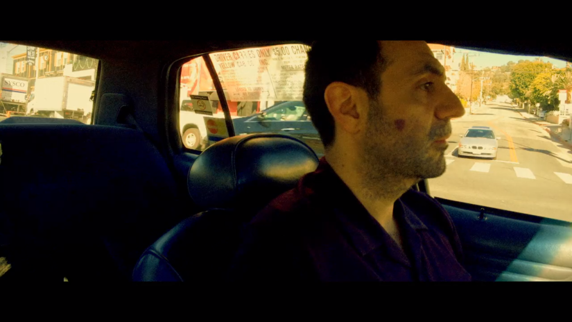 a man looks ahead, driving a taxi
