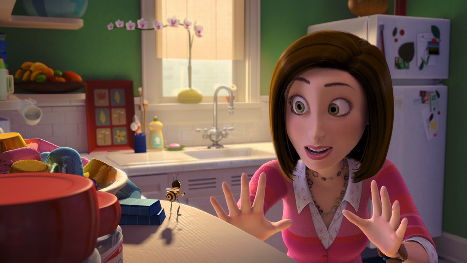 a woman dressed in a pink sweater talks to a bee standing on a kitchen counter