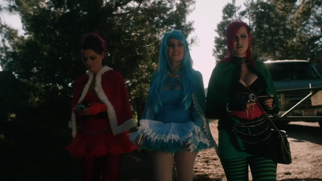three women walk together outside, dressed in revealing Christmas-themed costumes