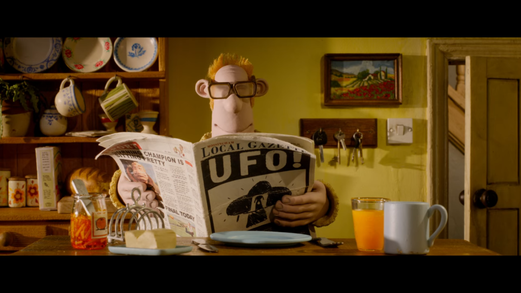 An animated man with thinning hair and thick glasses sits at a breakfast table, reading a newspaper with a headline about a UFO sighting.