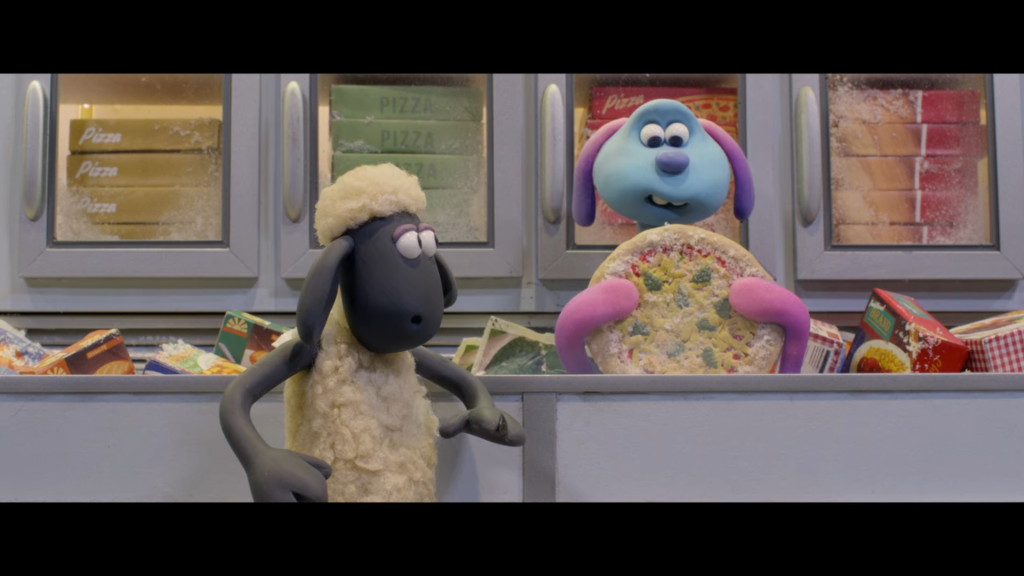 An animated sheep looks in alarm at a pink and purple creature resembling a dog. The creature sits in a bin of frozen food in a grocery store, holding a frozen pizza.