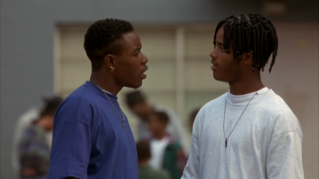 Two young men face each other as they hold an intense conversation.